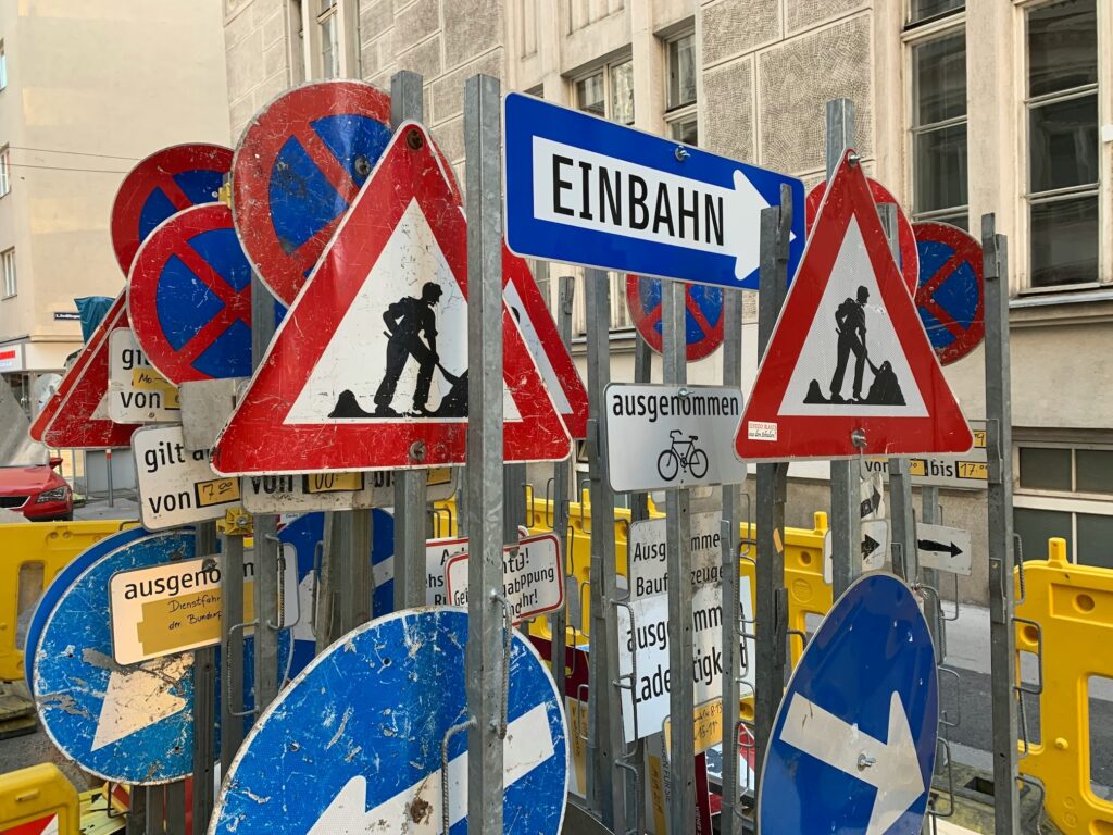 A bunch of different street signs propped up vertically in a rack